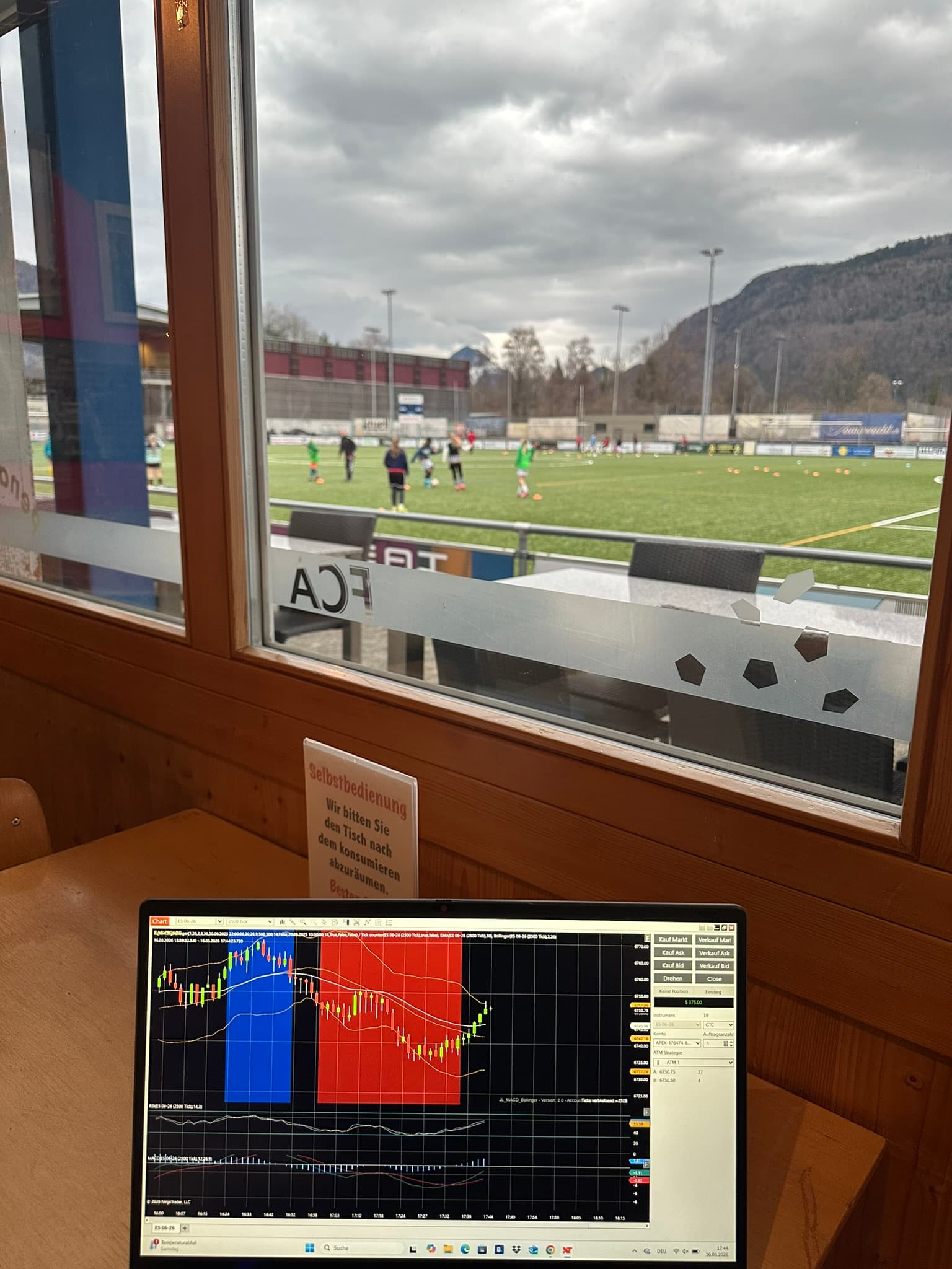 Laptop mit Trading-Charts am Fussballplatz